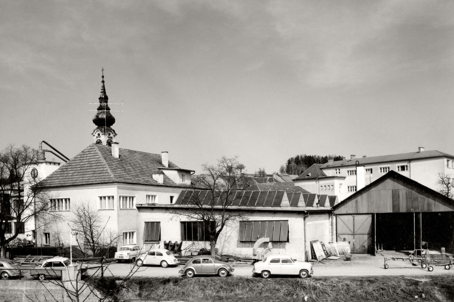 Часть центра города Грискирхен: первый цех PÖTTINGER примерно в 1960 году. «Жук» VW очень популярен среди сотрудников PÖTTINGER.