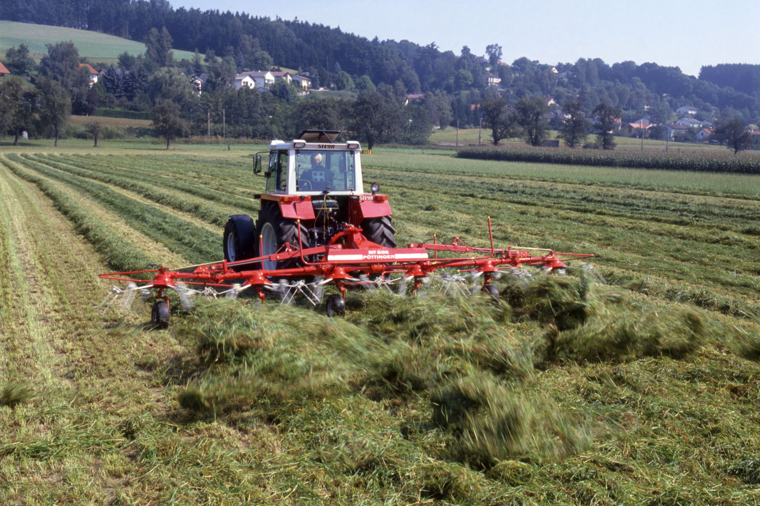 Знакомый снимок с запахом свежего сена: хитовое ворошение сена с ворошилкой HIT компании PÖTTINGER.